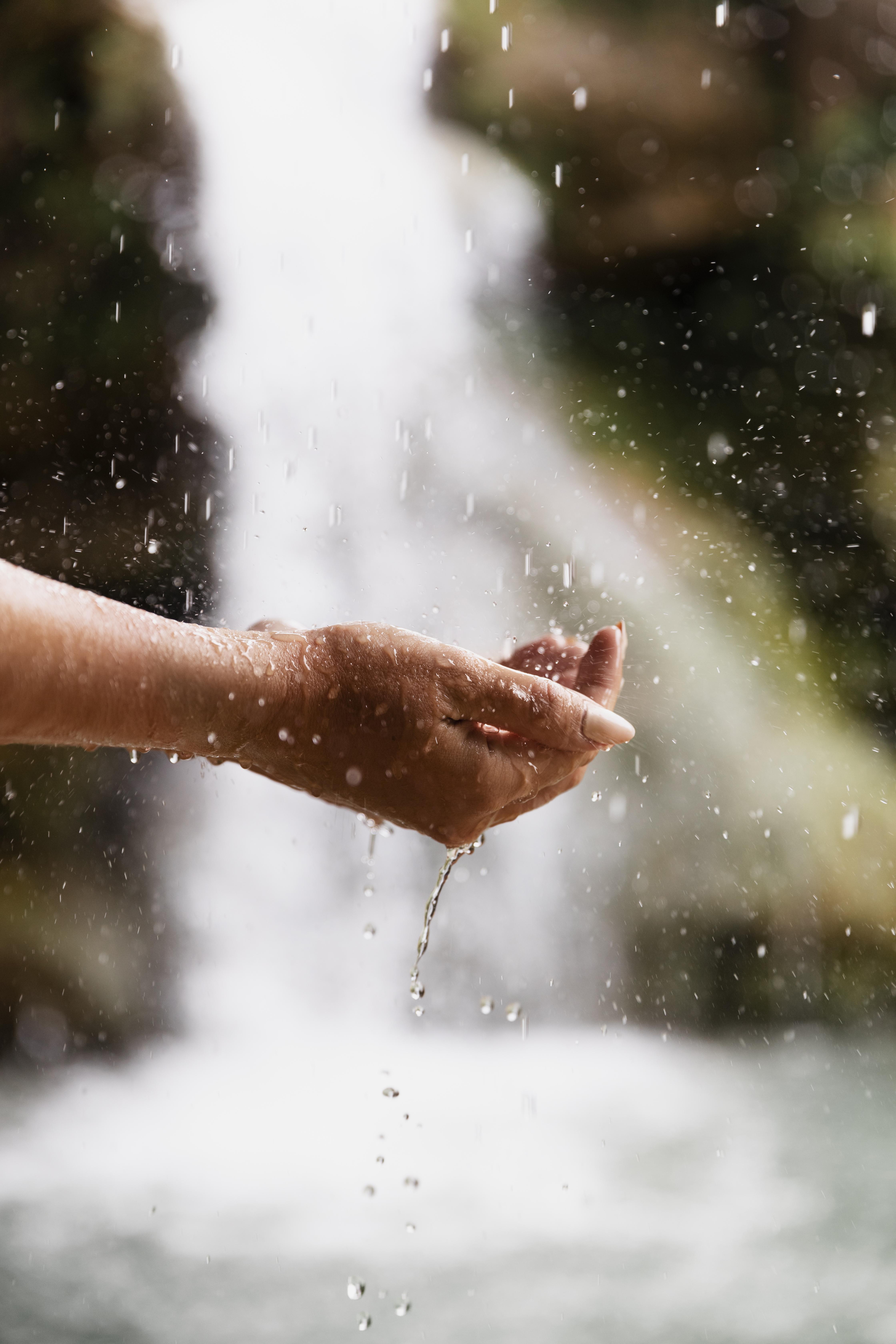 Hands cupping fresh water from nature
